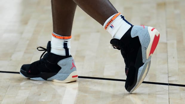 View of black, grey, and red Jordan Zion shoes.